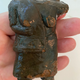 A ceramic ocarina fashioned in the shape of a human. Its head is missing.